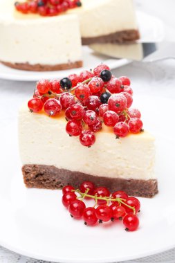 peynirli kek parçasını kırmızı ve siyah kuş üzümü ile dekore edilmiştir.