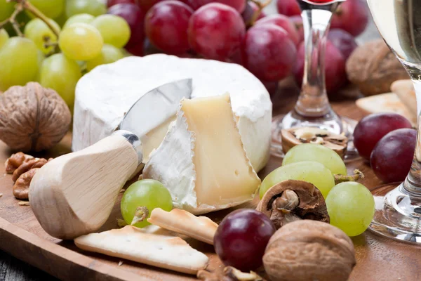 Camembert, bir kadeh kırmızı şarap, üzüm ve kraker, yakın çekim — Stok fotoğraf