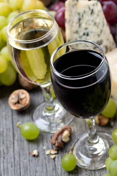 Vinho tinto e branco, uvas, nozes e queijos — Fotografia de Stock