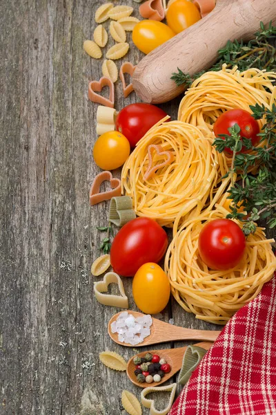 Makaron, pomidory i przyprawy na drewniane tła, widok z góry — Zdjęcie stockowe