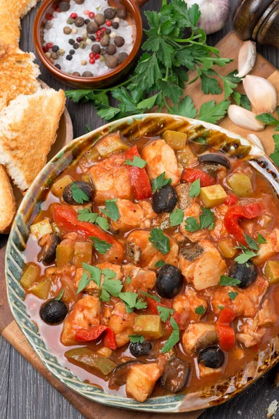 Fish stew in tomato sauce on a plate, vertical, top view — Stock Photo, Image