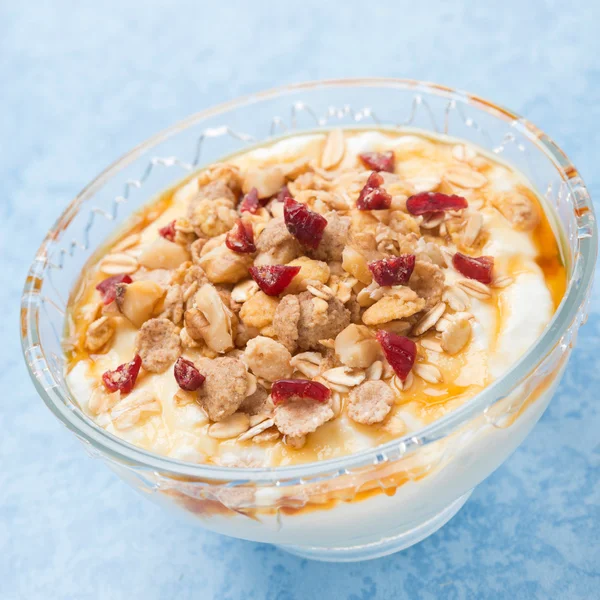 Yogurt con muesli, miele, bacche, primo piano — Foto Stock