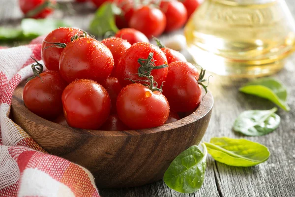 Bowl with fresh tomatoes, spinach and olive oil, close-up — Stock Photo, Image