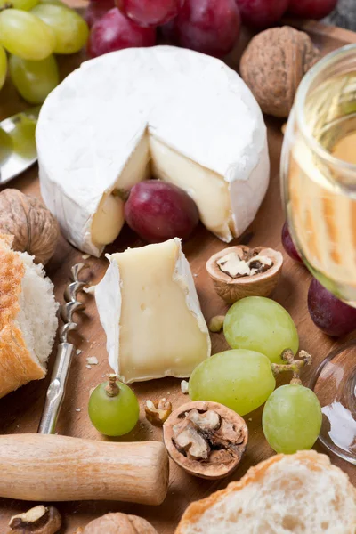 Camembert, copo de vinho branco, uvas e baguete fresco — Fotografia de Stock