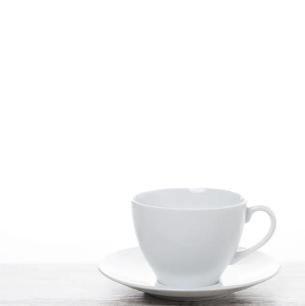Prázdný bílý šálek na bílý stůl a prostor pro text — Stock fotografie