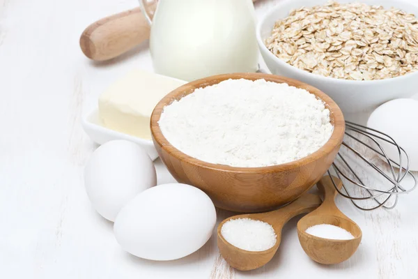 Milk, cereal and ingredients for baking on wooden table — Stock Photo, Image