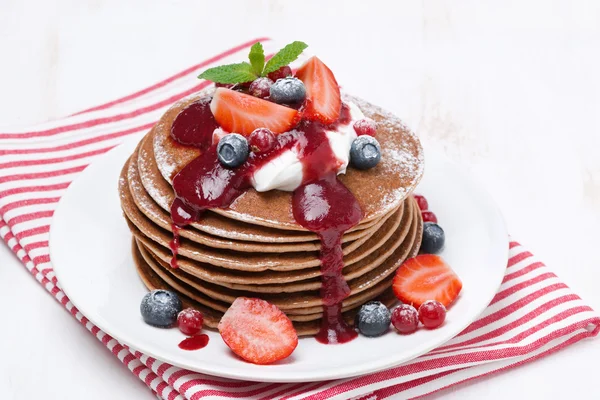 Pancakes with cream and berries on a white wooden table, closeup — Stock Photo, Image