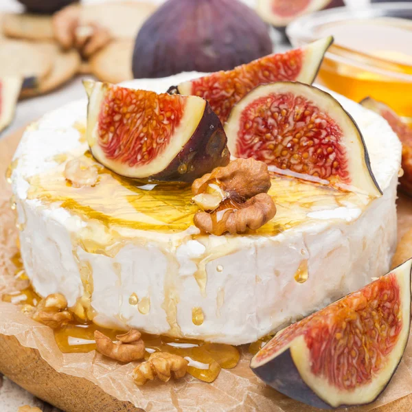 Camembert cheese with honey, figs and crackers on wooden board — Stock Photo, Image