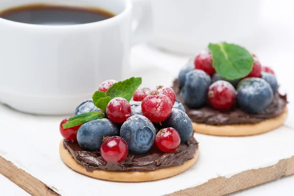 Delicious mini cakes with chocolate cream and fresh berries — Stock Photo, Image