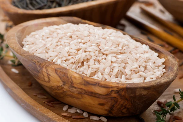 Rózsaszín csiszolatlan rizs egy fából készült tál, közelkép — Stock Fotó