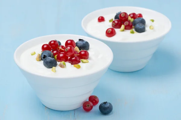 Dos tazones de yogur dulce fresco con bayas y pistachos — Foto de Stock