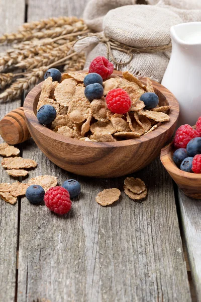 Wholegrain flakes with fresh berries and milk on wooden table — Stock Photo, Image