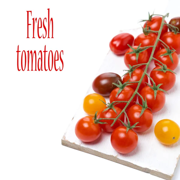 Kolorowe pomidory na biały deska, na białym tle — Zdjęcie stockowe