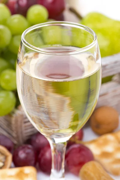 Glas Weißwein und Trauben im Hintergrund — Stockfoto