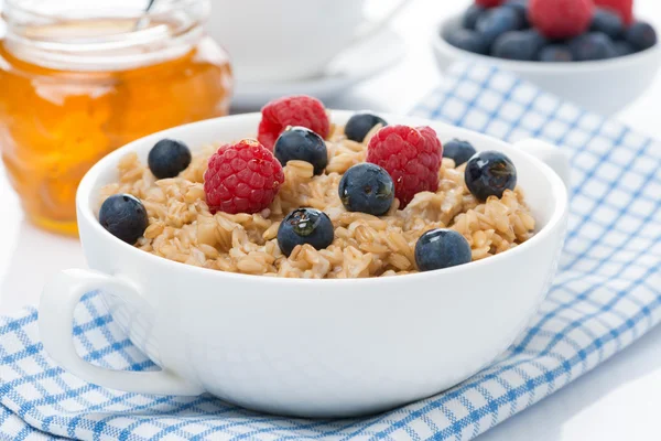 healthy breakfast - oat porridge with berries and honey