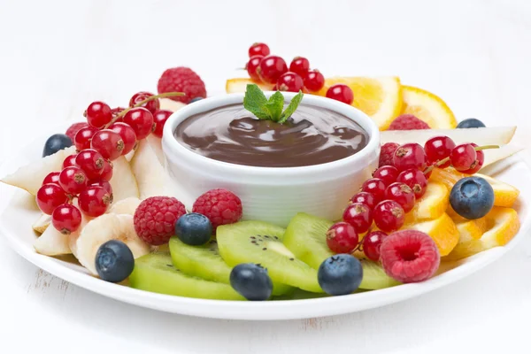 Surtido de frutas con salsa de chocolate en un plato, primer plano —  Fotos de Stock