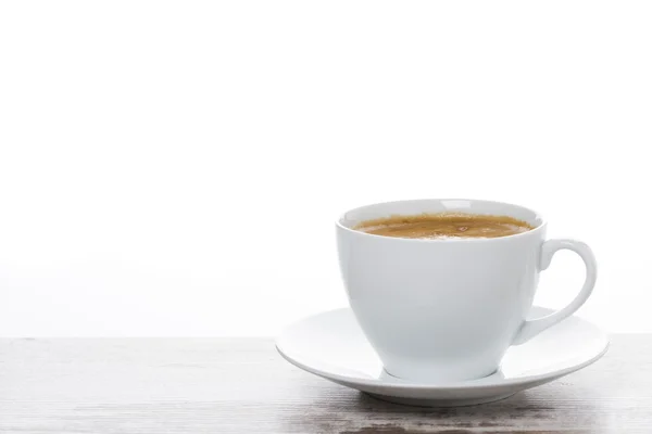 Taza de café en una mesa de madera blanca y espacio para el texto — Foto de Stock
