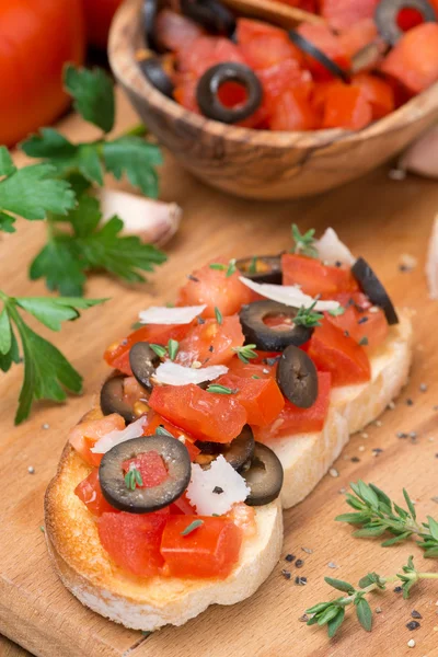Ciabatta with tomatoes, olives, parmesan on a wooden board — Stock Photo, Image