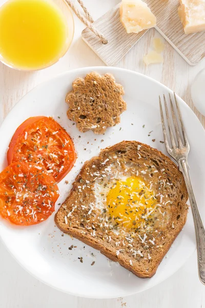 Fried egg in a toast and grilled tomatoes, top view — Stock Photo, Image