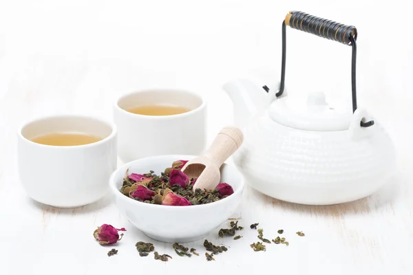 Zelený čaj s růžových poupat, šálky a konvice na bílý dřevěný stůl — Stock fotografie