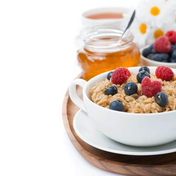 Oat porridge with fresh berries and honey, black tea, isolated — Stock Photo, Image