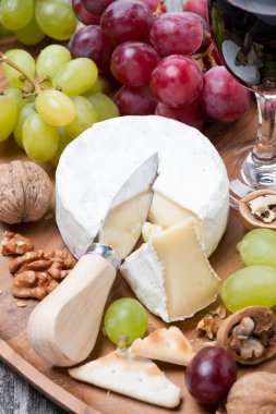 Camembert, bir kadeh kırmızı şarap, üzüm ve kraker