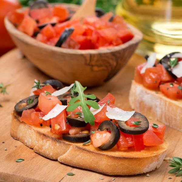 Ciabatta med tomater, oliver, parmesan på ett bräde — Stockfoto