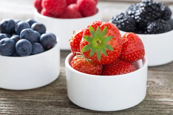 Fresh strawberries in a bowl and berries, closeup — Stock Photo, Image