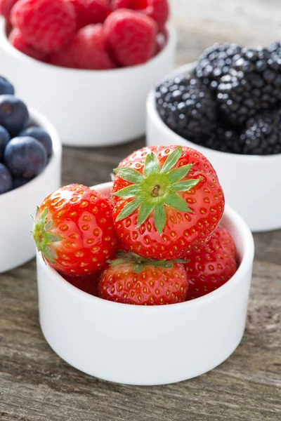 Fresas frescas en un tazón y bayas, primer plano, vertical —  Fotos de Stock