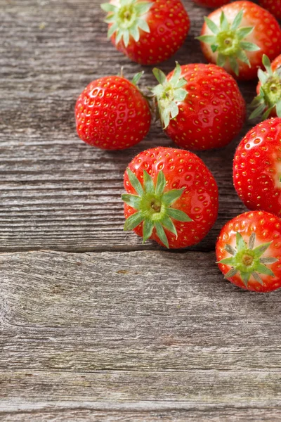 Färska jordgubbar på en trä bakgrund, vertikal — Stockfoto