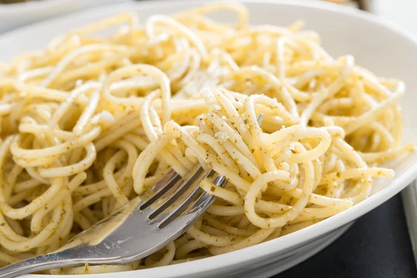 Prato de espaguete com pesto e queijo, close-up — Fotografia de Stock