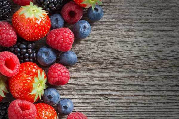 Holzhintergrund mit frischen Beeren, Draufsicht — Stockfoto