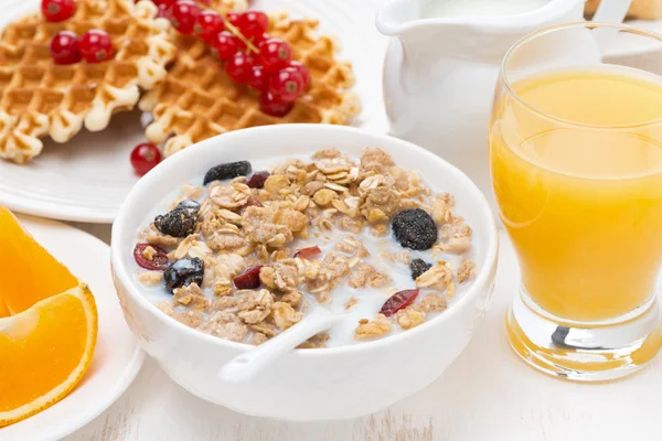 Muesli with milk, sweet waffles and orange juice for breakfast — Stock Photo, Image