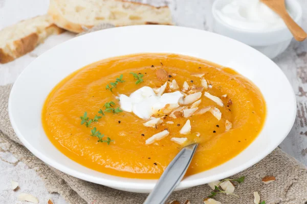 Carrot soup with almonds, yogurt and watercress in a plate — Stock Photo, Image