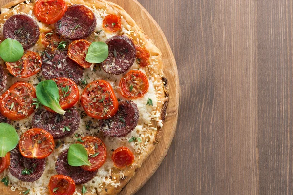 Italienische Pizza mit Salami und Tomaten auf einem Holztisch — Stockfoto