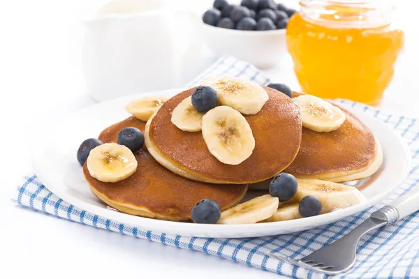 Pancakes with banana, honey and blueberries, isolated — Stock Photo, Image