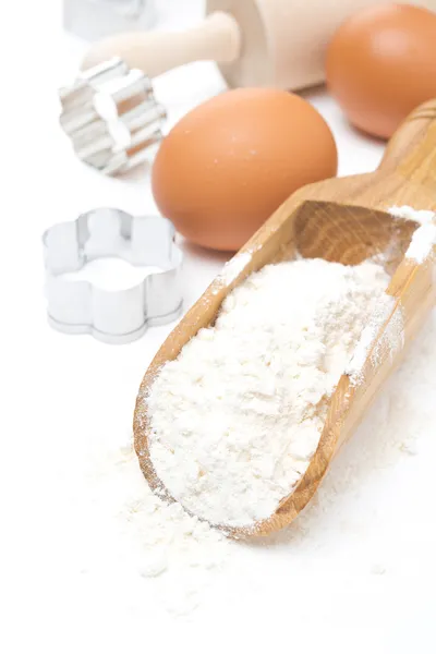 Schep met tarwe meel, eieren en cookie cutters geïsoleerd — Stockfoto