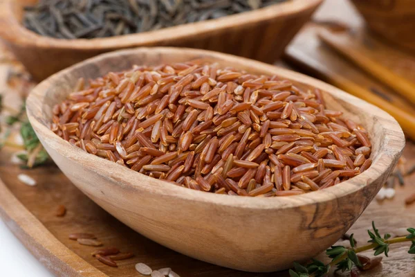 Arroz vermelho em uma tigela de madeira, close-up — Fotografia de Stock