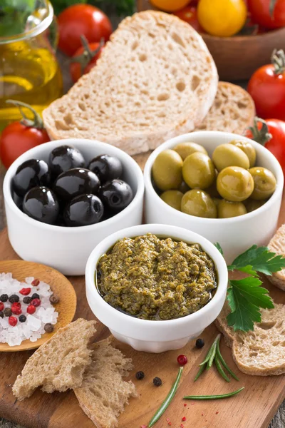 Sortiment av antipasti - oliver, pesto och bröd, vertikal — Stockfoto