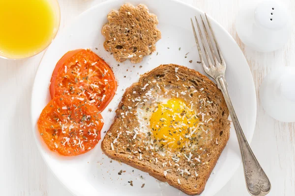 Fried egg in a toast and grilled tomatoes for breakfast — Stock Photo, Image