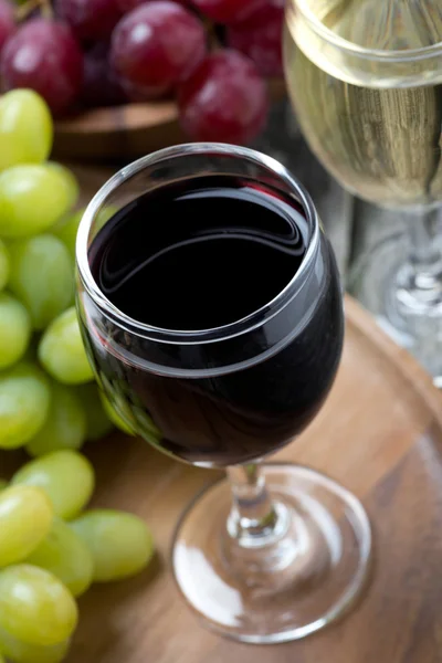 Glasses of red and white wine and grapes, top view — Stock Photo, Image