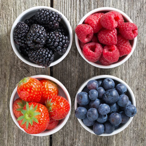 Aardbeien, bosbessen, bramen en frambozen in kommen — Stockfoto