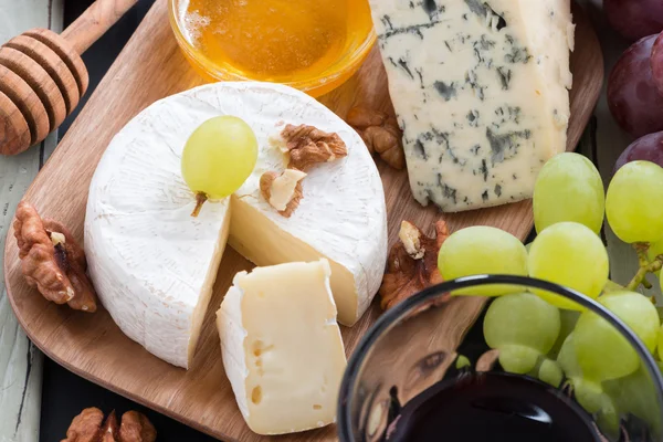 Surtido de aperitivos delicatessen - queso, uvas, galletas saladas — Foto de Stock