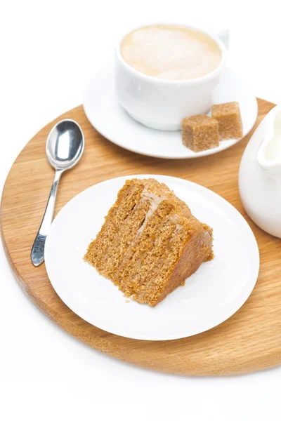 Piece of honey cake, jug of cream and cup of cappuccino — Stock Photo, Image