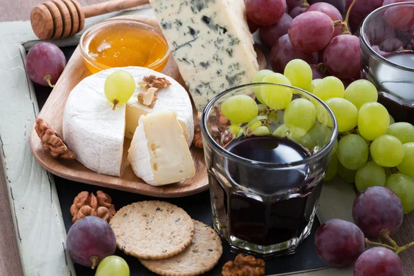 Assorted appetizers to wine - cheeses, fresh grapes, crackers — Stock Photo, Image