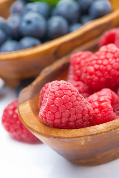 Fresh raspberries close-up and blueberries in a wooden bowls — Stock Photo, Image