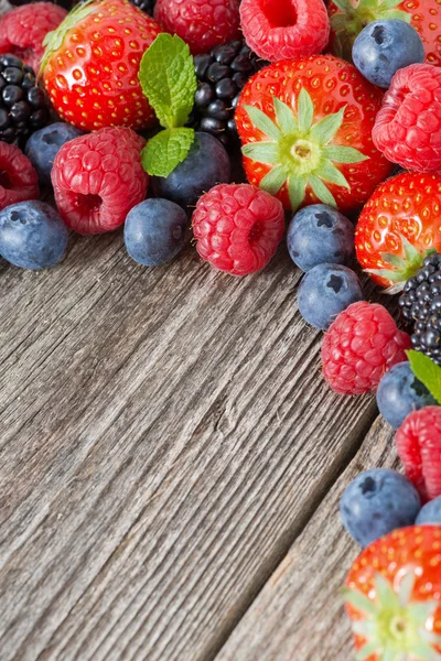 Wooden background with fresh berries and mint, top view — Stock Photo, Image