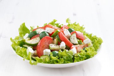 Beyaz tahta masada sebzeli yeşil salata