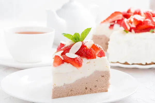 Stück Kuchen mit Schlagsahne, frischen Erdbeeren und Tee — Stockfoto