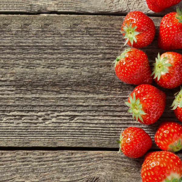 Fyrkantiga trä bakgrund med färska jordgubbar — Stockfoto